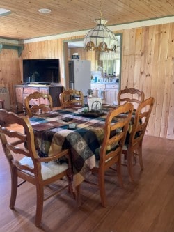 30 Idle Hour Way, Clinton, MT 59825 - dining space with wood walls, wooden ceiling, a chandelier, and wood finished floors