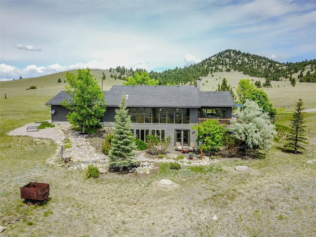 1087 Sunny Vista Rd, Helena, MT 59602 - rear view of property featuring a mountain view, a sunroom, and a shingled roof
