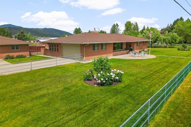 2709 Humble Rd, Missoula, MT 59804 - rear view of house with an attached garage, a chimney, a mountain view, brick siding, and a fenced backyard