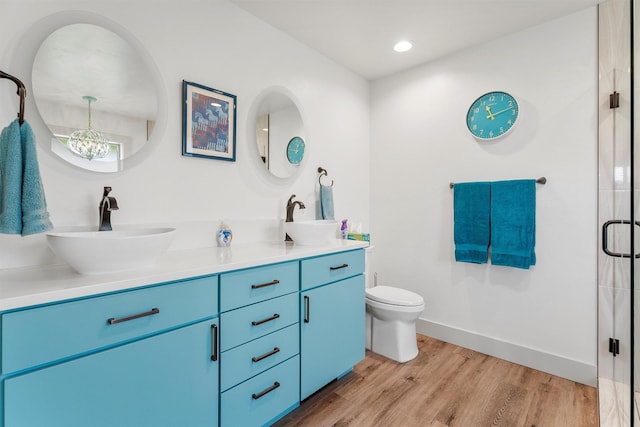 2709 Humble Rd, Missoula, MT 59804 - full bath featuring double vanity, wood finished floors, a chandelier, an enclosed shower, and recessed lighting