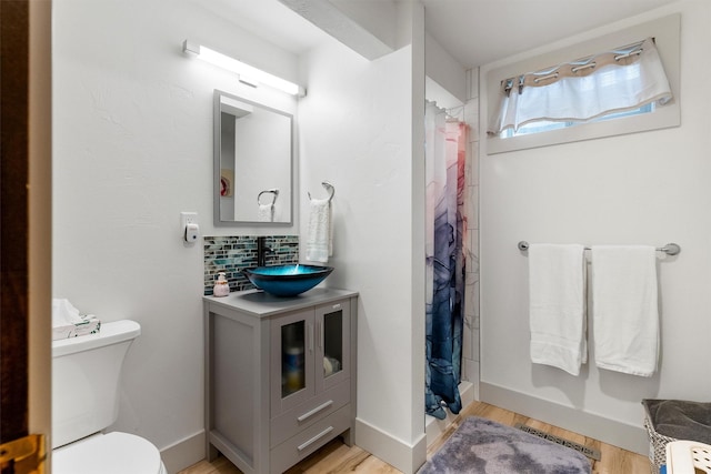 2709 Humble Rd, Missoula, MT 59804 - bathroom with vanity, a stall shower, tasteful backsplash, and wood finished floors