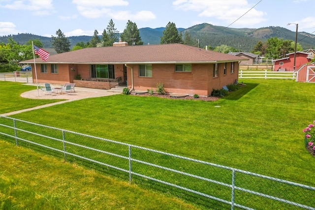 2709 Humble Rd, Missoula, MT 59804 - back of house with a mountain view, a patio area, brick siding, and a chimney