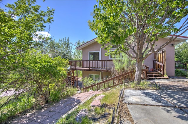 8319 Canyon Ferry Rd, Helena, MT 59602 - back of property featuring stairway, stucco siding, a wooden deck, and a patio area