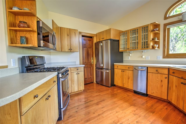 8319 Canyon Ferry Rd, Helena, MT 59602 - kitchen with appliances with stainless steel finishes, open shelves, light countertops, light wood-style flooring, and glass insert cabinets