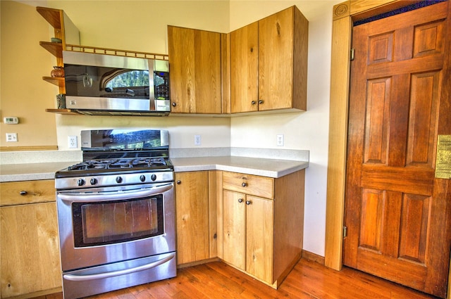8319 Canyon Ferry Rd, Helena, MT 59602 - kitchen with appliances with stainless steel finishes, light wood-style floors, light countertops, open shelves, and brown cabinets