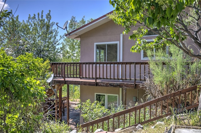 8319 Canyon Ferry Rd, Helena, MT 59602 - view of side of home with stucco siding, a deck, and stairs
