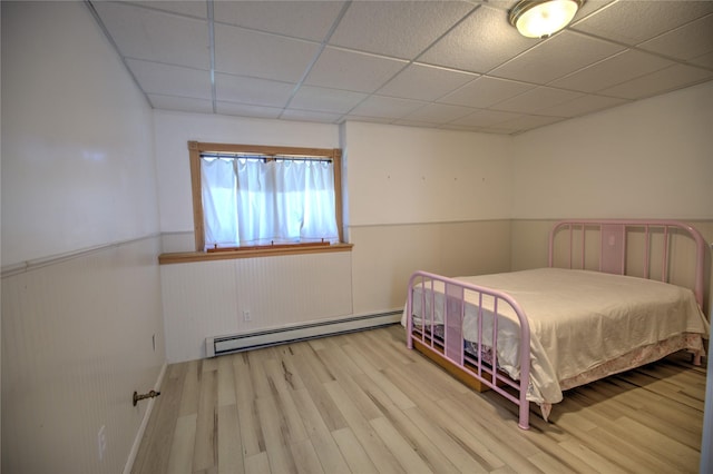 8319 Canyon Ferry Rd, Helena, MT 59602 - bedroom featuring a baseboard radiator, a paneled ceiling, wainscoting, and wood finished floors