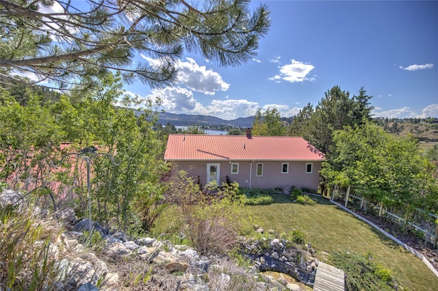8319 Canyon Ferry Rd, Helena, MT 59602 - back of house with a metal roof, stucco siding, a lawn, and a mountain view