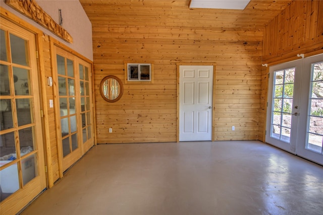 8319 Canyon Ferry Rd, Helena, MT 59602 - empty room with french doors, wooden walls, concrete flooring, and high vaulted ceiling