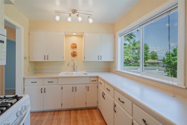 2129 E 6th Ave, Helena, MT 59601 - kitchen with white range with gas cooktop, light countertops, light wood-type flooring, and white cabinets