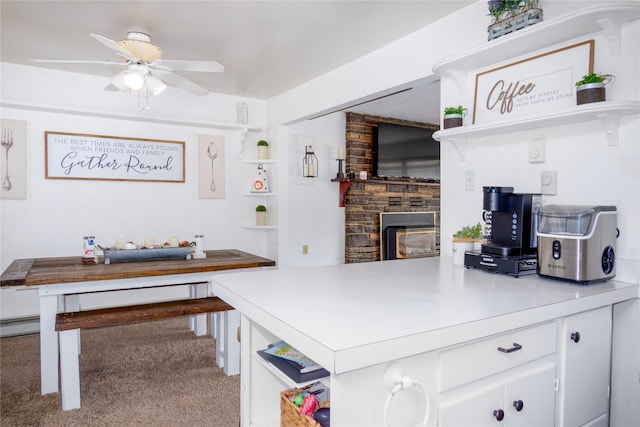 440 Dome Mountain Rd, Libby, MT 59923 - kitchen featuring open shelves, a glass covered fireplace, white cabinetry, ceiling fan, and a peninsula