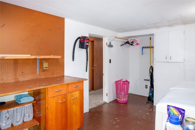 440 Dome Mountain Rd, Libby, MT 59923 - kitchen with finished concrete floors, separate washer and dryer, and white cabinetry