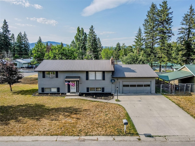 440 Dome Mountain Rd, Libby, MT 59923 - bi-level home with a garage, a metal roof, concrete driveway, a gate, and a chimney