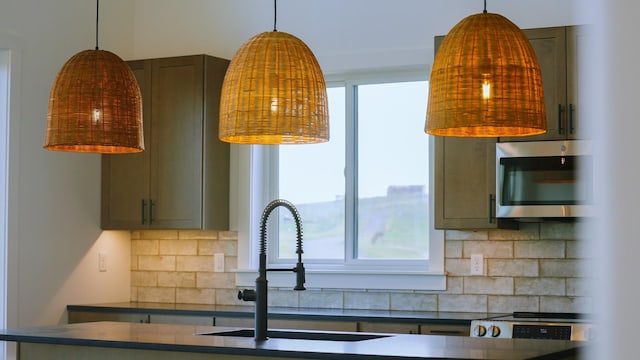 406 2nd Rd SW, Fairfield, MT 59436 - kitchen featuring stainless steel microwave, dark countertops, backsplash, and healthy amount of natural light