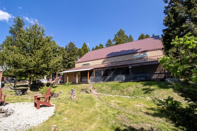 912 Muskrat Rd, Helmville, MT 59843 - rear view of property with a fire pit, a lawn, and a metal roof