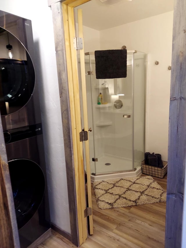 20536 Wild Horse Ranch Rd, Rollins, MT 59931 - bathroom featuring estacked washer and dryer, wood finished floors, and a stall shower