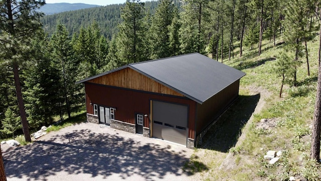 20536 Wild Horse Ranch Rd, Rollins, MT 59931 - view of outdoor structure featuring a wooded view, asphalt driveway, and a mountain view