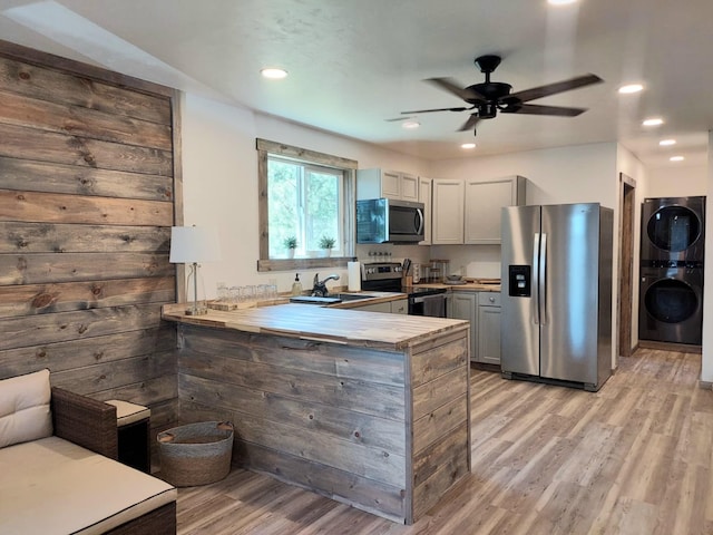 20536 Wild Horse Ranch Rd, Rollins, MT 59931 - kitchen with stainless steel appliances, estacked washer and dryer, a peninsula, light wood-style floors, and recessed lighting