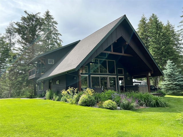 120 Chickadee Way, Whitefish, MT 59937 - rear view of house featuring a lawn, a shingled roof, and board and batten siding