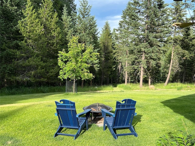 120 Chickadee Way, Whitefish, MT 59937 - view of grassy yard featuring a fire pit and a wooded view