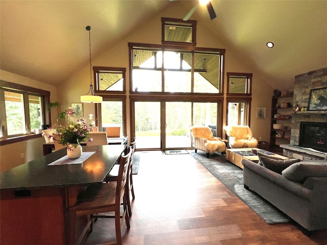 120 Chickadee Way, Whitefish, MT 59937 - living room featuring high vaulted ceiling, ceiling fan, wood finished floors, and a stone fireplace