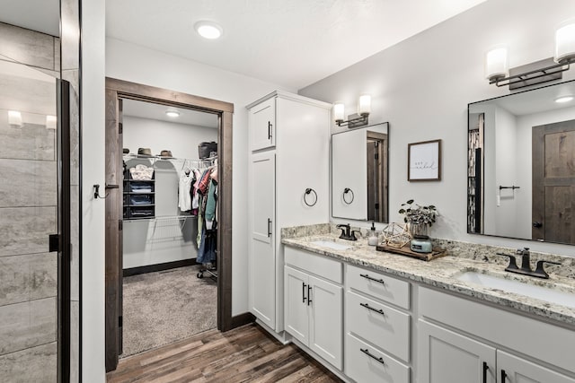 1 Arizona Rd, Great Falls, MT 59404 - bathroom featuring double vanity, wood finished floors, a walk in closet, a shower stall, and recessed lighting