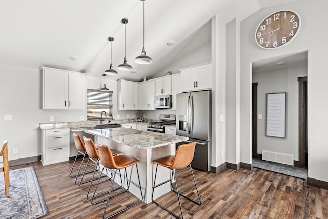 1 Arizona Rd, Great Falls, MT 59404 - kitchen featuring appliances with stainless steel finishes, dark wood finished floors, a kitchen breakfast bar, a kitchen island, and high vaulted ceiling