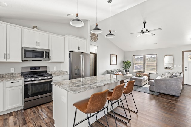 1 Arizona Rd, Great Falls, MT 59404 - kitchen featuring appliances with stainless steel finishes, vaulted ceiling, open floor plan, dark wood-style floors, and white cabinets