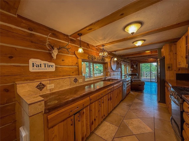 23254 Dayton Creek Rd, Proctor, MT 59929 - kitchen with dark countertops, black range with gas cooktop, freestanding refrigerator, beamed ceiling, and a chandelier