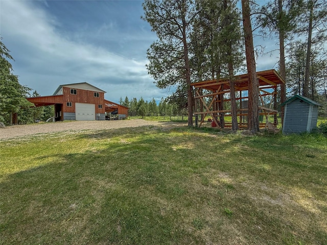 23254 Dayton Creek Rd, Proctor, MT 59929 - view of green lawn with driveway, an outdoor structure, a detached garage, and an outbuilding