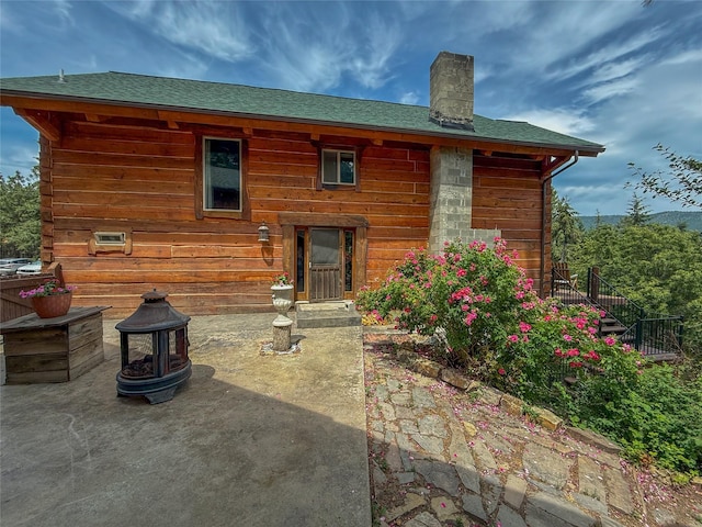 23254 Dayton Creek Rd, Proctor, MT 59929 - rear view of house with a chimney, a patio, and roof with shingles
