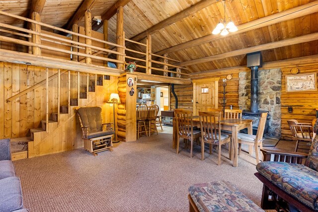 392 Leisure Ln, Sula, MT 59871 - dining area featuring log walls, a wood stove, wood ceiling, stairway, and carpet
