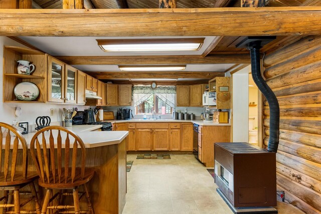 392 Leisure Ln, Sula, MT 59871 - kitchen with white microwave, a peninsula, under cabinet range hood, range with gas cooktop, and open shelves