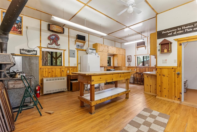 392 Leisure Ln, Sula, MT 59871 - kitchen featuring a wainscoted wall, ceiling fan, radiator, light wood finished floors, and wooden walls