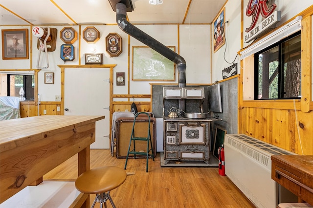 392 Leisure Ln, Sula, MT 59871 - kitchen with a wood stove, healthy amount of natural light, light wood-type flooring, a wainscoted wall, and wood walls