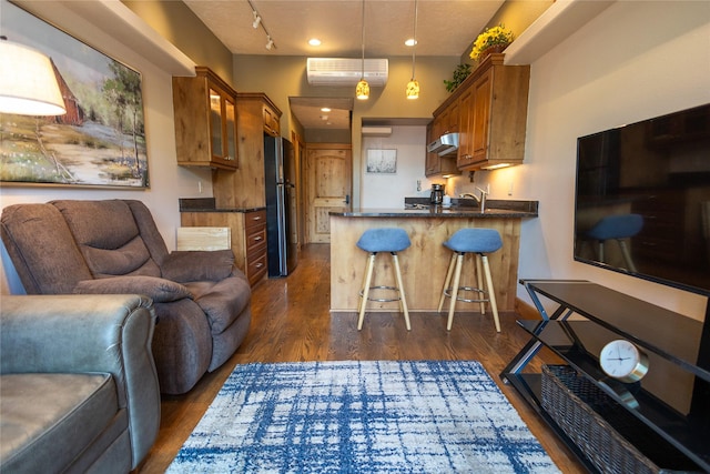 62 S Last Chance Gulch Gulch Unit 5, Helena, MT 59601 - kitchen with open floor plan, freestanding refrigerator, brown cabinetry, under cabinet range hood, and a peninsula