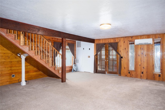 74 Cedar Crk, Libby, MT 59923 - carpeted spare room with a wall unit AC, wooden walls, stairway, and french doors