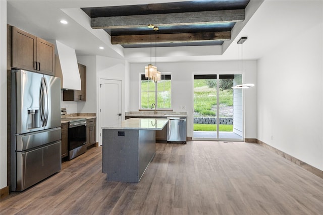 237 W Nicklaus Ave, Kalispell, MT 59901 - kitchen featuring appliances with stainless steel finishes, a raised ceiling, dark wood finished floors, a center island, and hanging light fixtures