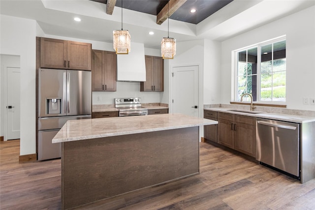 237 W Nicklaus Ave, Kalispell, MT 59901 - kitchen with appliances with stainless steel finishes, dark wood-type flooring, a kitchen island, range hood, and light stone countertops
