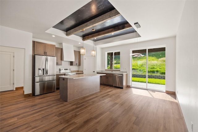 237 W Nicklaus Ave, Kalispell, MT 59901 - kitchen with stainless steel appliances, dark wood finished floors, light countertops, a tray ceiling, and a kitchen island
