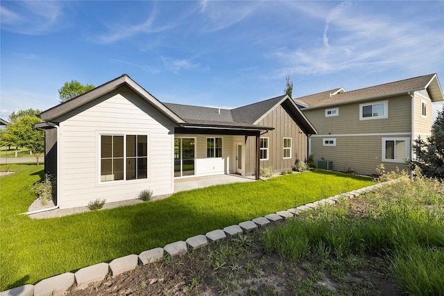237 W Nicklaus Ave, Kalispell, MT 59901 - rear view of property featuring board and batten siding, a patio, and a lawn