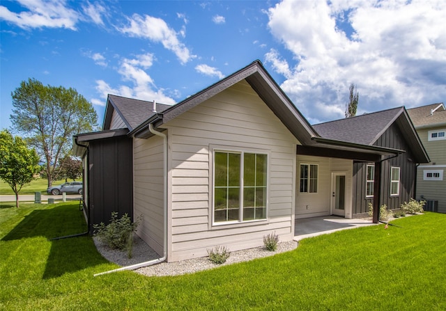 237 W Nicklaus Ave, Kalispell, MT 59901 - back of house with a patio, a lawn, board and batten siding, and roof with shingles