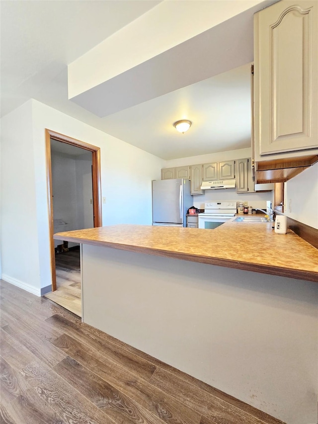 1401 Park Garden Rd, Great Falls, MT 59404 - kitchen with freestanding refrigerator, white electric range, a peninsula, under cabinet range hood, and wood finished floors