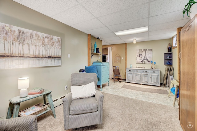 216 W Riggs St, East Helena, MT 59635 - living area featuring a baseboard radiator, carpet floors, and a paneled ceiling