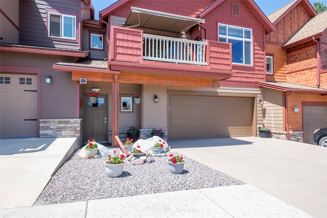 467 Ridgeway Dr, Lolo, MT 59847 - view of front of property featuring a balcony, an attached garage, concrete driveway, and stone siding