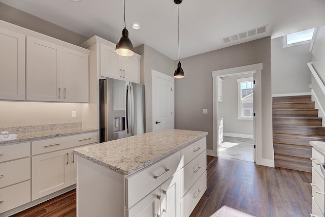 2933 Travis Ave, Helena, MT 59601 - kitchen featuring stainless steel refrigerator with ice dispenser, white cabinets, dark wood-type flooring, decorative light fixtures, and light stone countertops