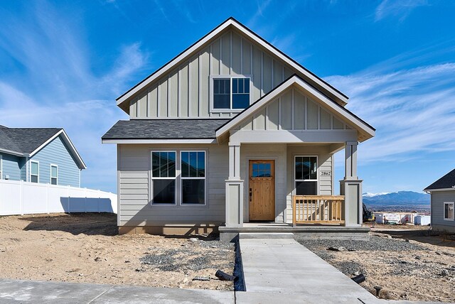 2933 Travis Ave, Helena, MT 59601 - view of front facade featuring board and batten siding, covered porch, a mountain view, and a shingled roof