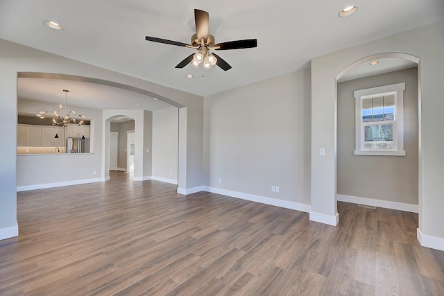 2933 Travis Ave, Helena, MT 59601 - empty room featuring a ceiling fan, dark wood-style flooring, recessed lighting, a chandelier, and arched walkways