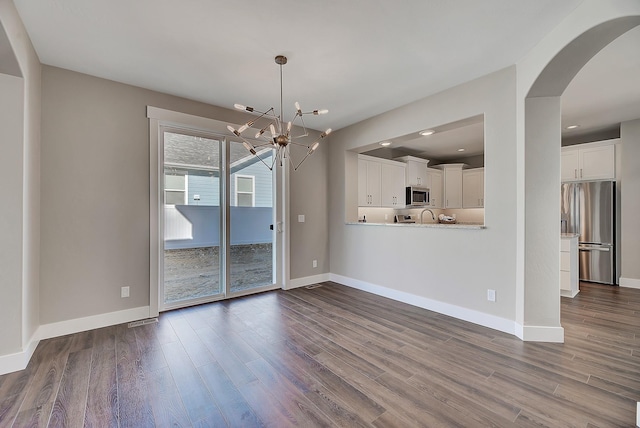 2933 Travis Ave, Helena, MT 59601 - unfurnished dining area featuring a chandelier, dark wood finished floors, arched walkways, and recessed lighting