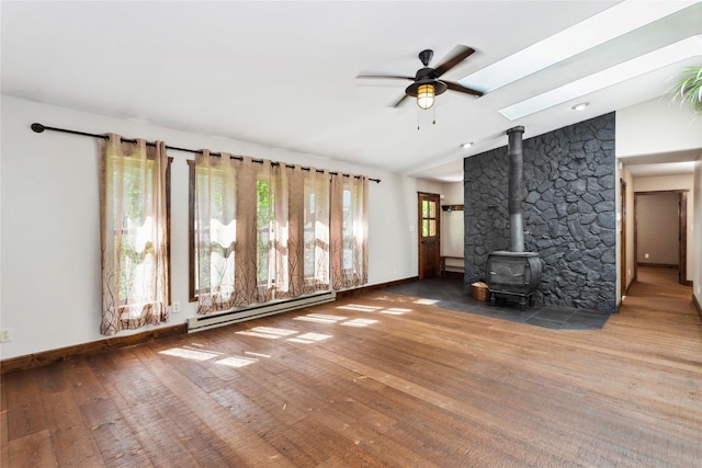 28578 Wapiti Ln, Bigfork, MT 59911 - unfurnished living room featuring a baseboard radiator, healthy amount of natural light, a wood stove, wood finished floors, and lofted ceiling